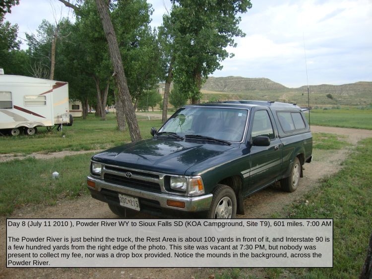 Day 8 (July 11 2010 ), Powder River WY to Sioux Falls SD (KOA Campground, Site T9), 601 miles. 7:00 AM

The Powder River is just behind the truck, the Rest Area is about 100 yards in front of it, and Interstate 90 is a few hundred yards from the right edge of the photo. This site was vacant at 7:30 PM, but nobody was present to collect my fee, nor was a drop box provided. Notice the mounds in the background, across the Powder River.