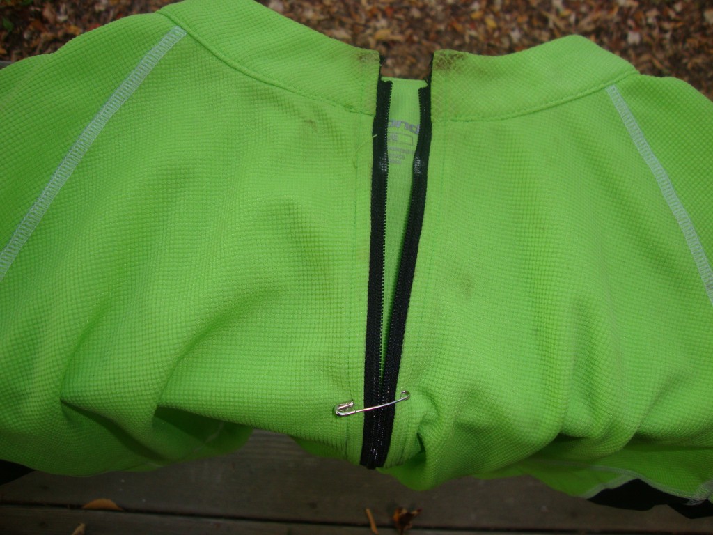 This nice riding jersey's zipper slider was frozen near where the pin is now. With pliers I got it  to the top but, unable to free it, cut it off and opened the zipper just enough to allow for over-the-head use.