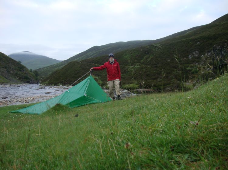 At 5:45 AM on Tuesday July 12 (Day 47), I'm ready to break camp at Falls of Tarf. This shot looks southwest, with the trail I'll be taking after I cross the bridge outlined behind my shoulders. The jacket is just for warmth.