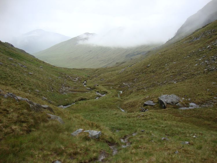 This was my view ahead, at 3:45 PM; there was no trail as I began the northward descent along the stream Allt Cairnean. The footing was wet, muddy, and rocky. Occasionally I would see previous walkers' bootprints. 