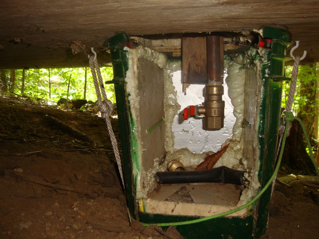 The Cathouse revealed!
In place with its door removed, here's the cathouse (some junk is lying on the floor). The lake valve, of course, is now closed so the system can be used. The final step at the closing of camp is to remove the cathouse, open the lake valve, and, when the draining stops, replace the cathouse.