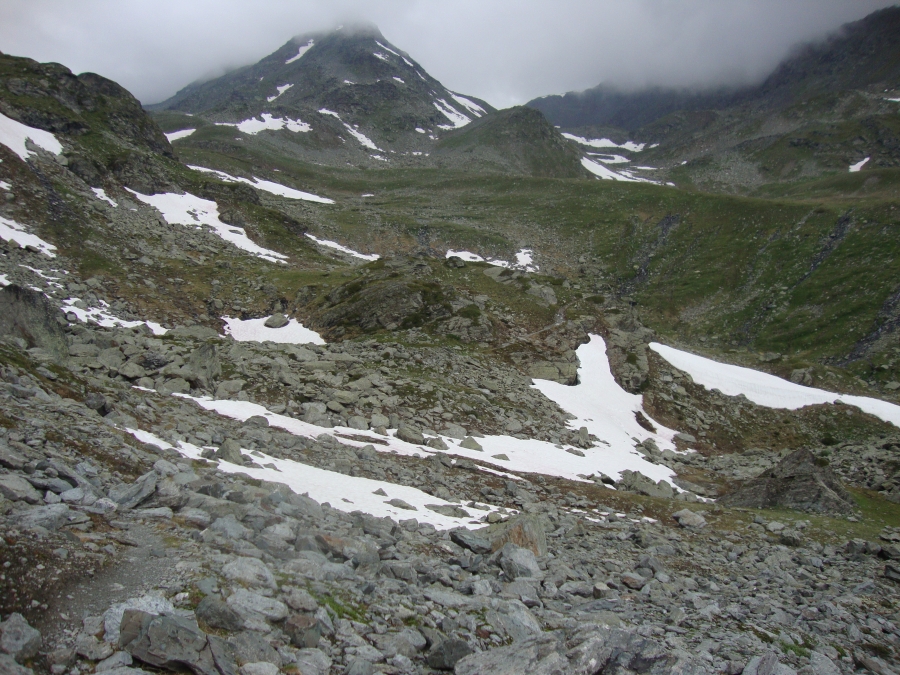 At 3:00 PM, this is the trail ahead, between me and Augstbord Pass. I haven't seen anyone since that lone hiker half an hour ago. The elevation here is 2425m, so there's still almost half a kilometer yet to ascend! In rain, thunder, and sleet, I'd donned rain gear half an hour earlier. Pretty desolate! I found it both exhilarating and frightening.  